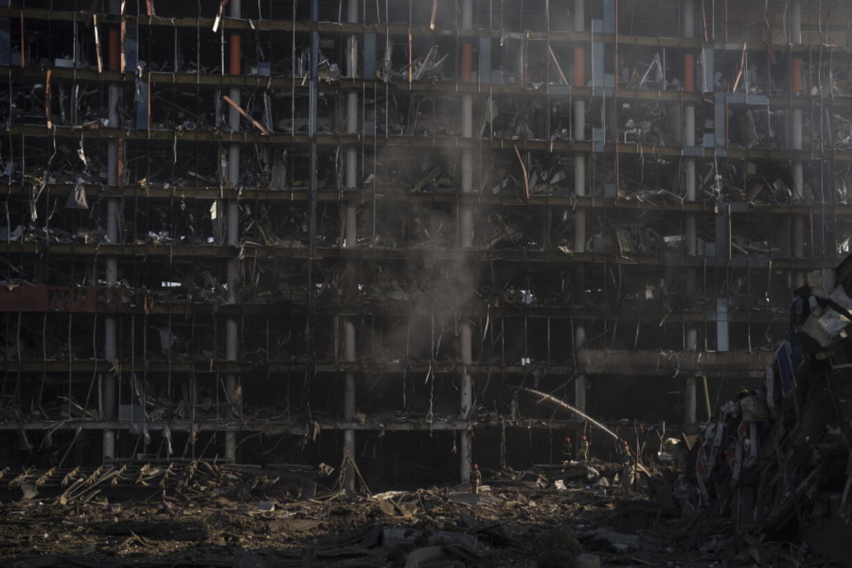 Firefighters extinguish a fire at a shopping center following a bombing in Kyiv, Ukraine, Monday, March 21, 2022.