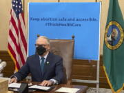 Washington Gov. Jay Inslee is seen before signing a measure that prohibits legal action against both people seeking an abortion and those who aid them, on Thursday, March 17, 2022, in Olympia, Wash. Inslee's signature comes days after the Legislature in neighboring Idaho approved a bill modeled on a law in Texas that allows lawsuits to enforce a ban on abortions performed after six weeks of pregnancy.