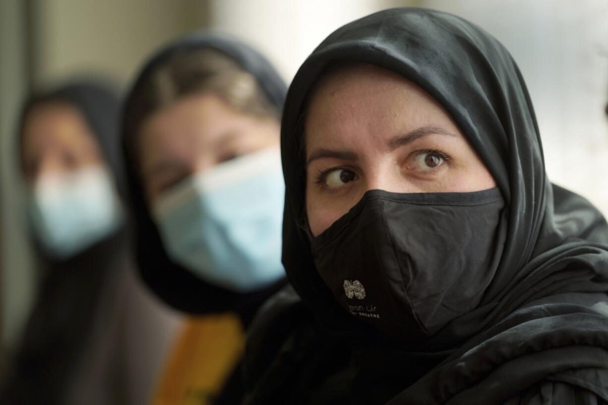 Afghan refugee Mozhgan Entazari, right, talks about the challenge to find proper housing for her family in Southern California, during an interview at a hotel lobby in Irvine, Calif., Tuesday, Feb. 15, 2022. Entazari, 34, said it took four months to find a home. On Sunday, they will move into a five-bedroom house in Corona, about 50 miles southeast of Los Angeles, that is renting for $4,000.