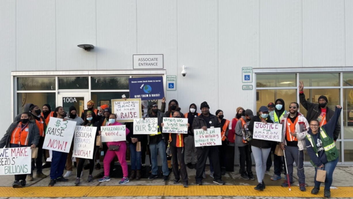 Amazon workers hold sigs after walking out of the Amazon DMD9 delivery station in Upper Marlboro, Md., on Wednesday, March 16, 2022.  A labor organizer says more than 60 Amazon workers across three delivery stations staged a walkout on Wednesday to demand a $3 raise and a return to 20-minute breaks. The walkout is being organized by a group called Amazonians United, which said in a statement that its demands were first brought up in December through a coordinated petition among six Amazon warehouses in the East Coast.