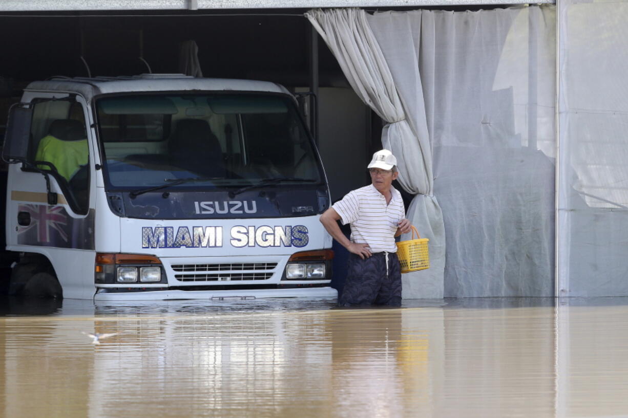 A man inspects the damage at a farm in Logan, south of Brisbane, Australia, Tuesday, March 1, 2022. Tens of thousands of people had been ordered to evacuate their homes by Tuesday and many more had been told to prepare to flee as parts of Australia's southeast coast are inundated by the worst flooding in decades.