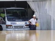 A man inspects the damage at a farm in Logan, south of Brisbane, Australia, Tuesday, March 1, 2022. Tens of thousands of people had been ordered to evacuate their homes by Tuesday and many more had been told to prepare to flee as parts of Australia's southeast coast are inundated by the worst flooding in decades.