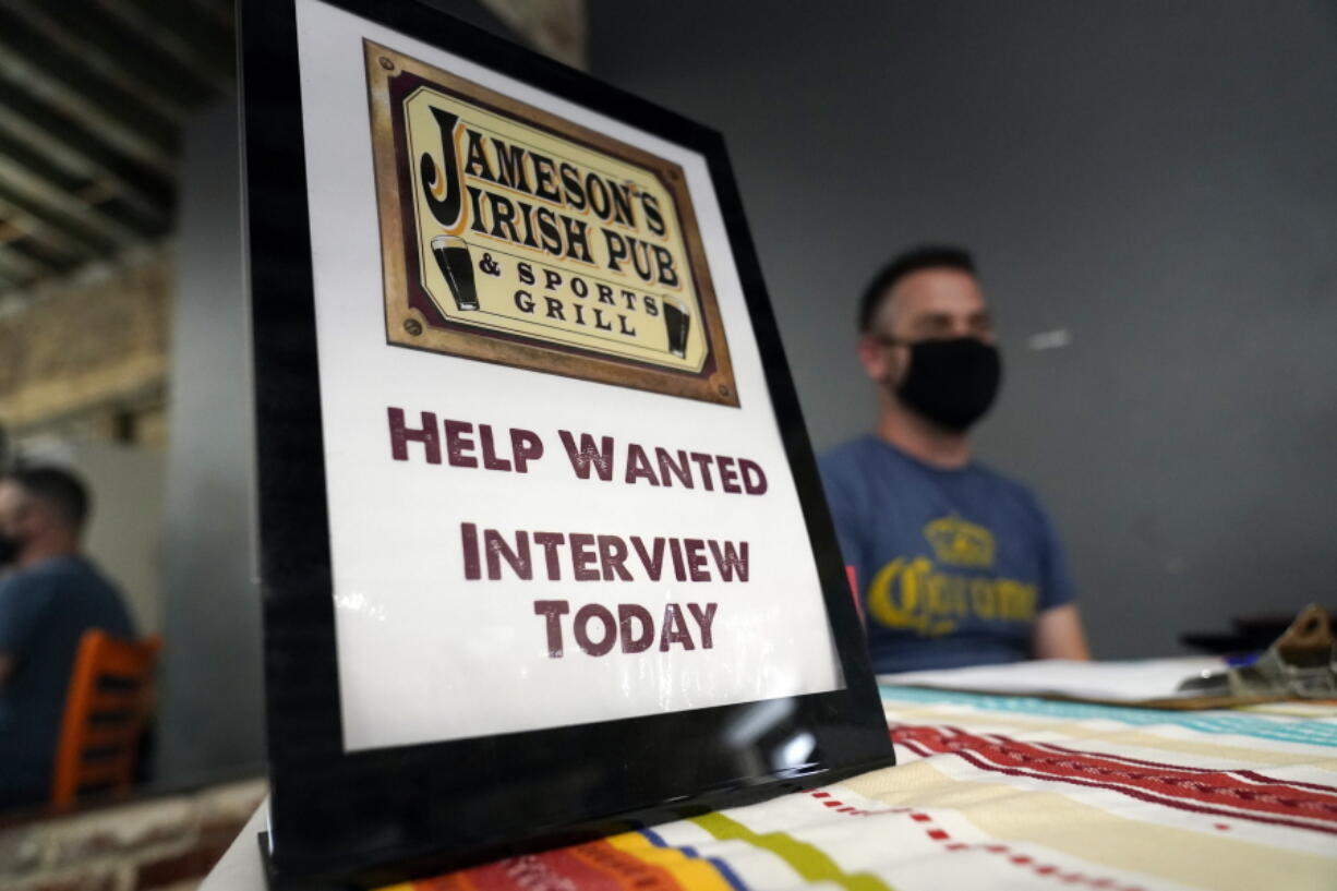 FILE - A hiring sign is shown at a booth for Jameson's Irish Pub during a job fair on Sept. 22, 2021, in the West Hollywood section of Los Angeles. California's unemployment rate has fallen to 5.4% after employers added a surprising 138,100 jobs in February.