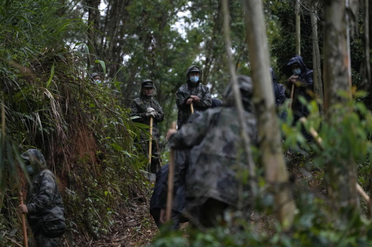 Search and rescue workers pause along a trail near the China Eastern crash site Thursday, March 24, 2022, in Molang village, in southwestern China's Guangxi province.