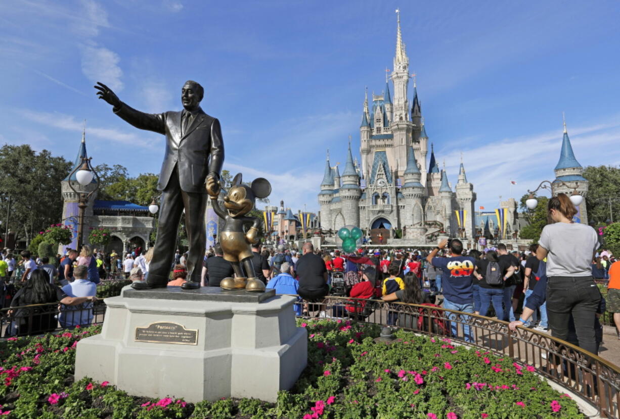 FILE - A statue of Walt Disney and Micky Mouse stand near the Cinderella Castle at the Magic Kingdom at Walt Disney World in Lake Buena Vista, Fla. on Jan. 9, 2019. With some workers across the U.S. threatening a walkout Tuesday, March 22, 2022, The Walt Disney Co. finds itself in a balancing act between the expectations of a diverse workforce and demands from an increasingly polarized, politicized marketplace.