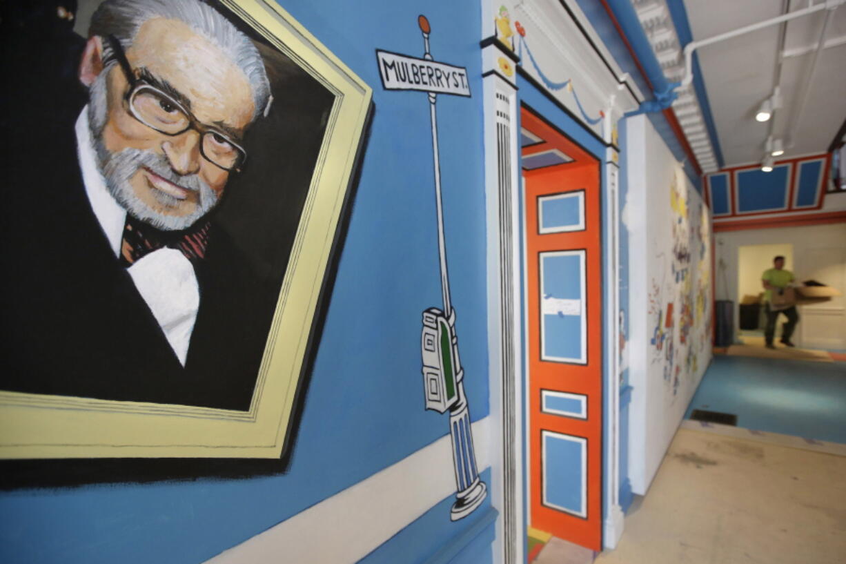 FILE -- A mural that features Theodor Seuss Geisel, left, also known by his pen name Dr. Seuss, covers part of a wall near an entrance at The Amazing World of Dr. Seuss Museum, May 4, 2017, in Springfield, Mass. Sketches of fantastic creatures by Dr. Seuss that have never before been published will see the light of day in new books being written and illustrated by an inclusive group of up-and-coming authors and artists, the company that owns the intellectual property rights to Dr. Seuss' works announced Wednesday, March 2, 2022.