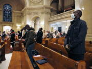 Paul Ndong, right, joins dozens of parishioners for a French Mass at the Church of Notre Dame in New York, on Sunday, March 6, 2022. Many parishioners come from former French and Belgium colonies in West and Central Africa, like Senegal, Ivory Coast, Mali, Togo and Congo.