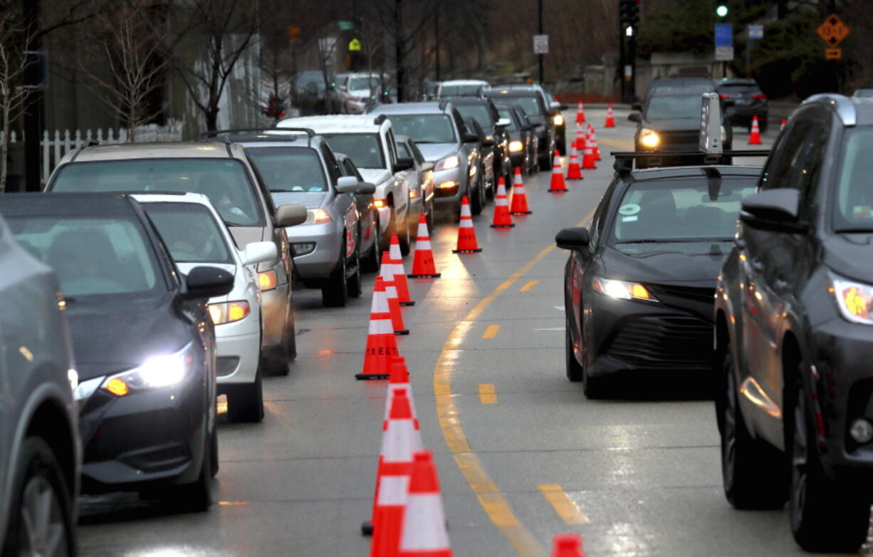 Cars line up early morning along Green Bay Road waiting to receive free gas donated by Willie Wilson at the Mobil Gas Station on Thursday, March 24, 2022, in Evanston, Ill.