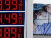 Prices are displayed on a sign at a gas station in Milwaukee on Monday with a billboard for medical services in the background.