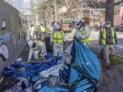 City of Seattle workers remove tents, trash, and personal belongings from a stretch of sidewalk across from City Hall that had been used by people experiencing homelessness, on March 9, 2022, in Seattle. For years, liberal cities in the U.S have tolerated people living in tents in parks and public spaces, but increasingly leaders in places like Portland, Oregon, New York and Seattle are removing encampments and pushing other strict measures that would've been unheard of a few years ago.