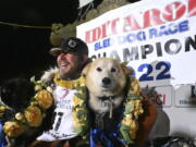 Iditarod winner Brent Sass poses for photos with lead dogs Morello, left, and Slater in the finish chute of the Iditarod Trail Sled Dog Race in Nome, Alaska, Tuesday March 15, 2022.