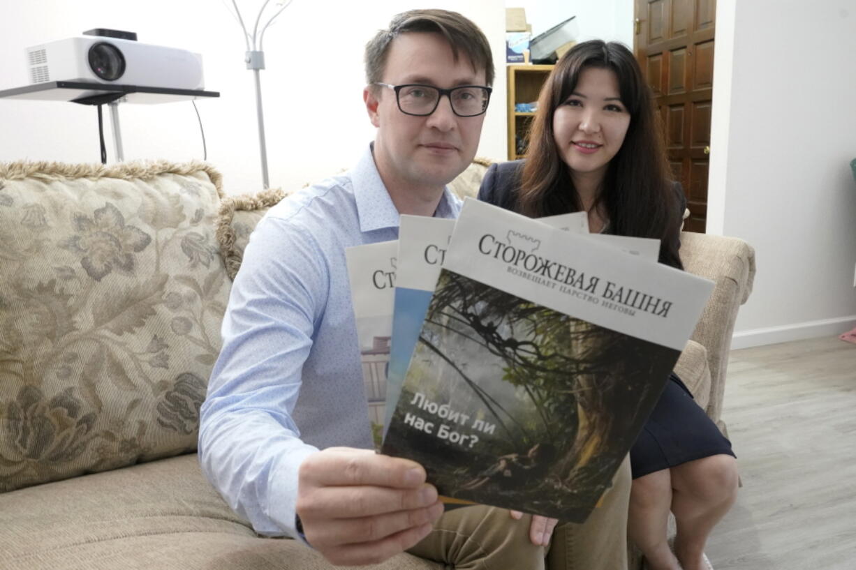 Dmitrii and Nellia Antsybor, who are from Russia and sought asylum in the United States in 2021, show Jehovah's Witness Watchtower literature printed in Russian on Feb. 28 at the home where they are living in Federal Way. (Ted S.