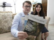 Dmitrii and Nellia Antsybor, who are from Russia and sought asylum in the United States in 2021, show Jehovah's Witness Watchtower literature printed in Russian on Feb. 28 at the home where they are living in Federal Way. (Ted S.