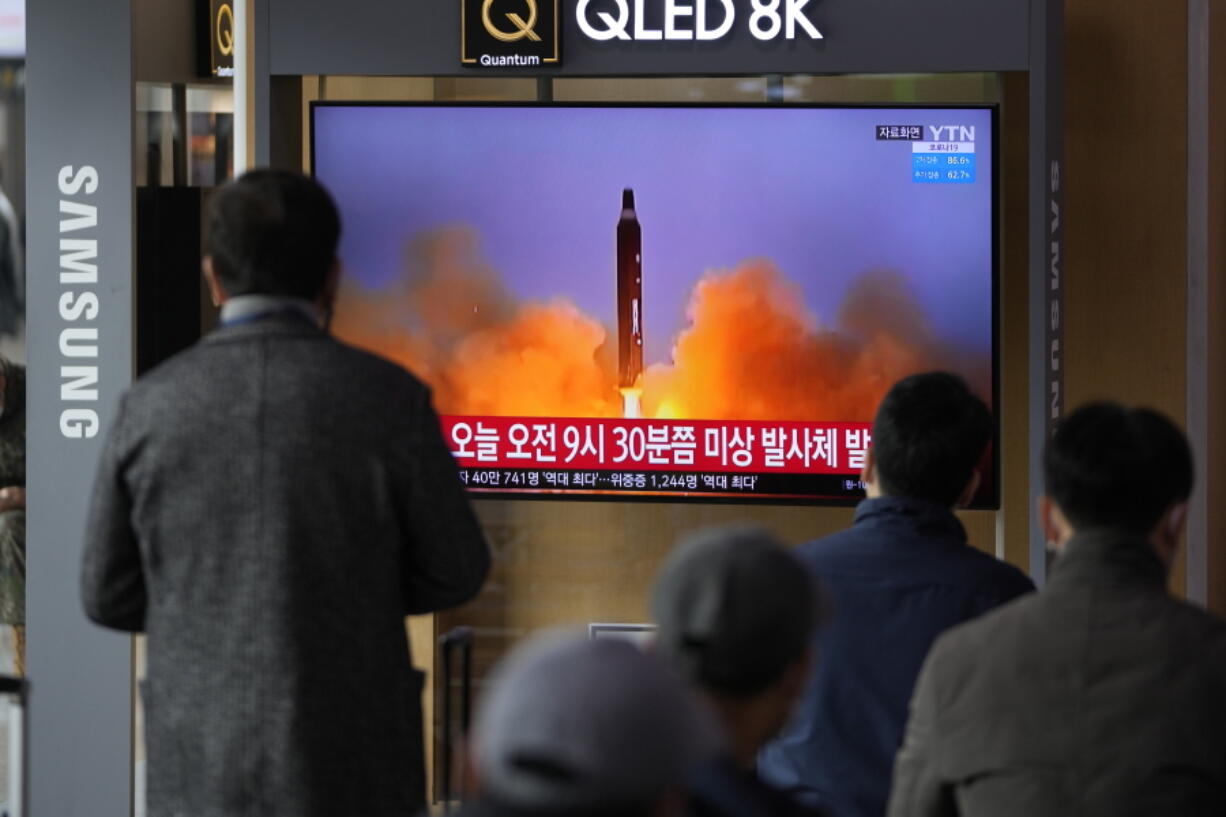 People watch a TV screen showing a news program reporting about North Korea's missile with file footage, at a train station in Seoul, South Korea, Wednesday, March 16, 2022. North Korea's latest weapons launch on Wednesday apparently ended in failure, South Korea' military said, amid speculation that the North could soon launch its biggest long-range missile in its most significant provocation in years.