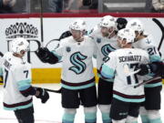 Seattle Kraken defenseman Carson Soucy, center, celebrates with right wing Jordan Eberle (7), defenseman Vince Dunn (29), center Alex Wennberg (21), and center Jaden Schwartz (17) after scoring a goal against the Arizona Coyotes during the second period of an NHL hockey game Tuesday, March 22, 2022, in Glendale, Ariz.