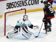 Ottawa Senators center Josh Norris (9) watches the puck go off the crossbar against Seattle Kraken goaltender Chris Driedger (60) during the third period of an NHL hockey game Thursday, March 10, 2022 in Ottawa, Ontario.(Justin Tang/The Canadian Press via AP)