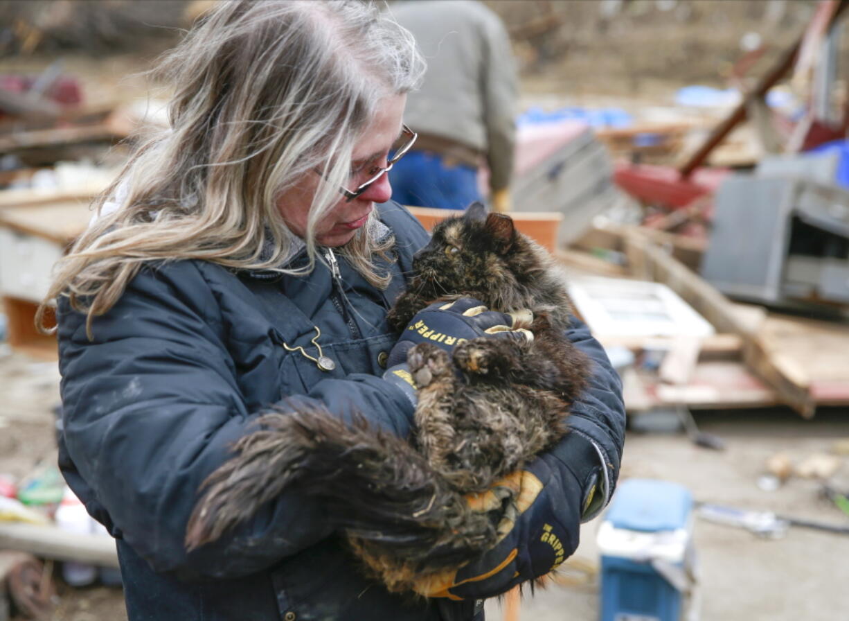 Betty Hope of Winterset, Iowa, holds Matilda, her 15-year-old longhaired tabby cat, outside of her tornado-ravaged home on Sunday, March 6, 2022. Hope had feared all three of her cats perished after Saturday's tornado.