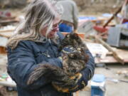 Betty Hope of Winterset, Iowa, holds Matilda, her 15-year-old longhaired tabby cat, outside of her tornado-ravaged home on Sunday, March 6, 2022. Hope had feared all three of her cats perished after Saturday's tornado.