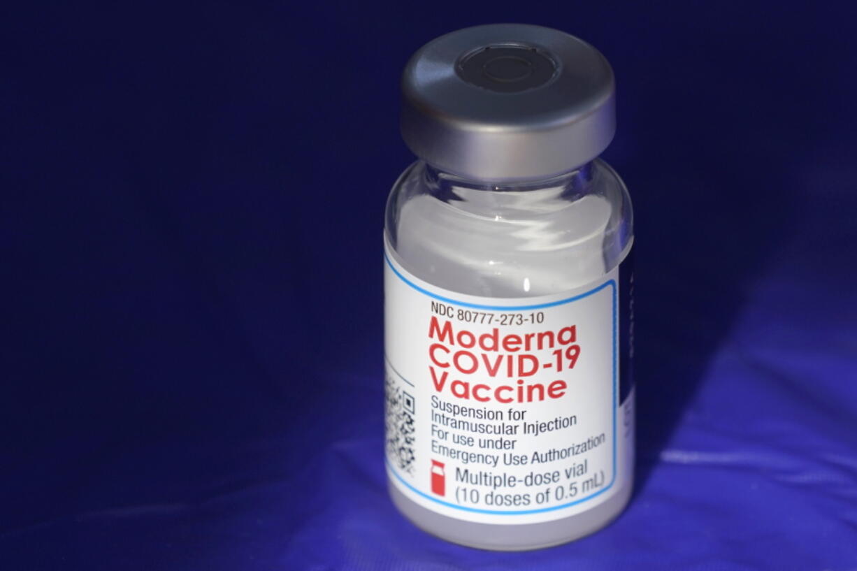 FILE - In this March 4, 2021 file photo, a vial of the Moderna COVID-19 vaccine rests on a table at a drive-up mass vaccination site in Puyallup, Wash., south of Seattle.  Moderna's COVID-19 vaccine brought in nearly $7 billion in the final quarter of 2021, and the drugmaker says it has signed purchase agreements for another $19 billion in sales this year.   (AP Photo/Ted S.