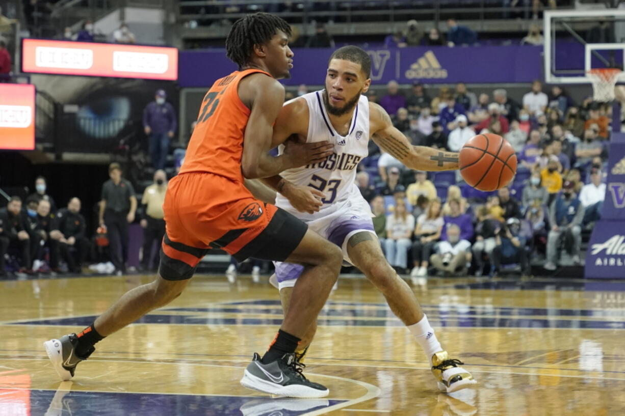 Washington guard Terrell Brown Jr., right, drives around Oregon State forward Glenn Taylor Jr., left, during the second half of an NCAA college basketball game, Saturday, March 5, 2022, in Seattle. Washington won 78-67. (AP Photo/Ted S.