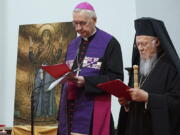 The spiritual leader of the world's Orthodox Christians, Ecumenical Patriarch Bartholomew I, right, and Archbishop Stanis?aw G?decki, the head of the Polish Bishops' Conference, stand together as they meet with Ukrainian refugees in Warsaw, Poland, on March 29, 2022.