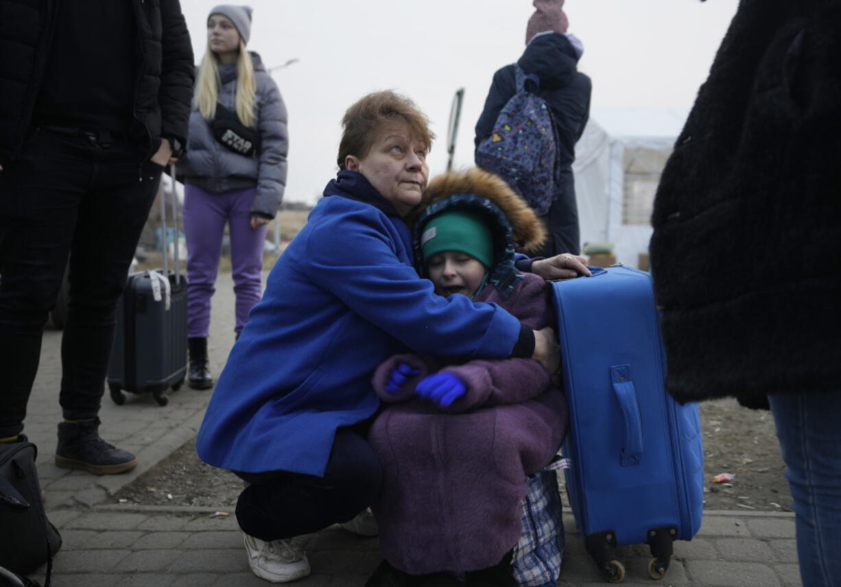 A woman holds a small girl at a border crossing, up as refugees flee a Russian invasion, in Medyka, Poland, Thursday, March 3, 2022. The U.N. refugee agency said Thursday at least 1 million people have fled Ukraine since Russia's invasion a week ago, an exodus without precedent in this century for its speed.