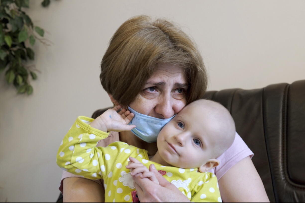 A Ukrainian grandmother holds her 22-month-old granddaughter with leukemia, Yeva Vakulenko, at a clinic in Bocheniec, Poland, on Thursday, March 17, 2022. Vakulenko is among more than 500 Ukrainian children with cancer who have been evacuated so far to a clinic in Poland. They are evaluated by doctors who then decide where they should go next for treatment. Some 200 hospitals in about 28 countries are accepting the children.