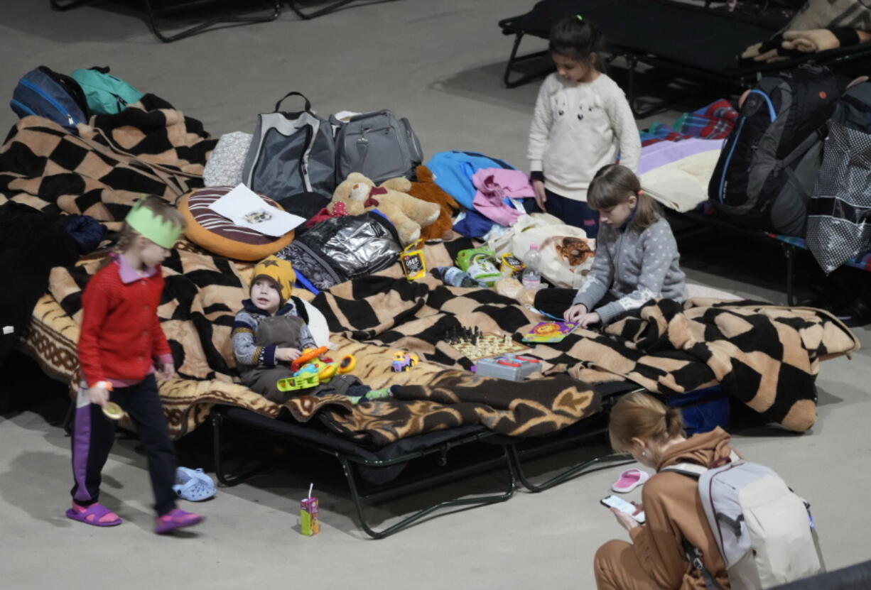 A boy holds a toy as he rests Friday in a center for Ukrainian refugees in Warsaw, Poland. Warsaw has become overwhelmed by refugees, with more than a tenth of all those fleeing the war in Ukraine arriving in the Polish capital, prompting Warsaw's mayor to appeal for international help.