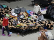 A boy holds a toy as he rests Friday in a center for Ukrainian refugees in Warsaw, Poland. Warsaw has become overwhelmed by refugees, with more than a tenth of all those fleeing the war in Ukraine arriving in the Polish capital, prompting Warsaw's mayor to appeal for international help.