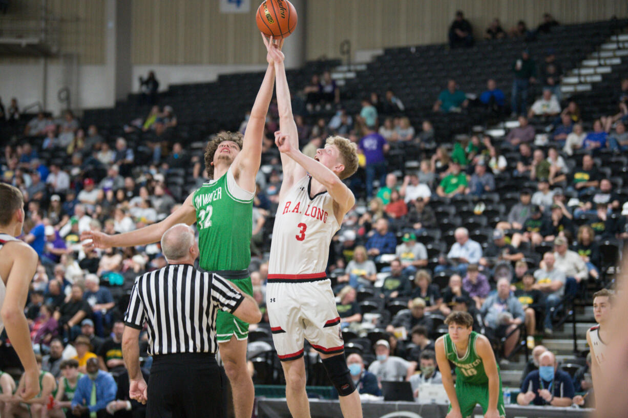 Tumwater's Ryan Otton (22) and R.A. Long's Aaron Ofstun vie for the opening tip at the state of a Class 2A state boys basketball quarterfinal game on Thursday in Yakima.