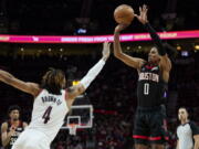 Houston Rockets guard Jalen Green, right, shoots over Portland Trail Blazers forward Greg Brown III during the second half of an NBA basketball game in Portland, Ore., Friday, March 25, 2022.