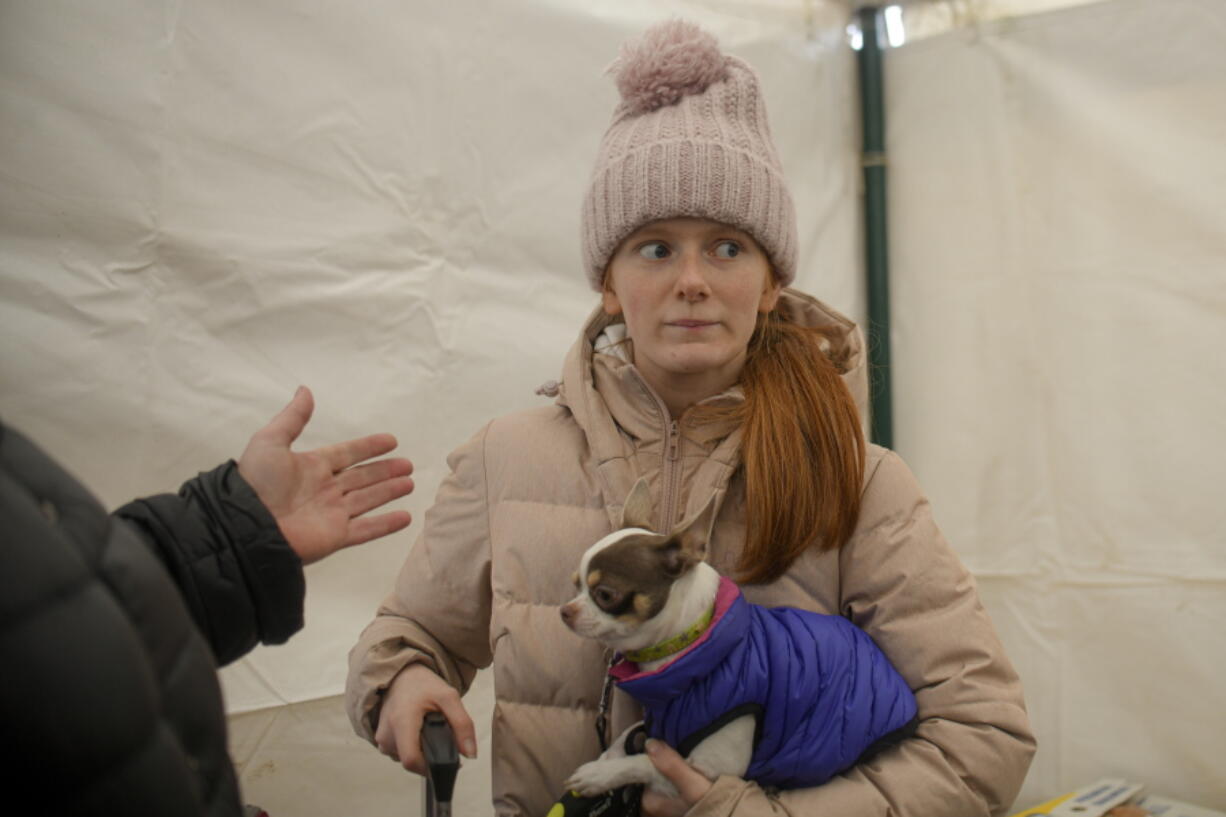 Margot, 15 years-old, refugee fleeing the conflict from neighbouring Ukraine holds her dog inside a tent at the Romanian-Ukrainian border, in Siret, Romania, Saturday, March 5, 2022.