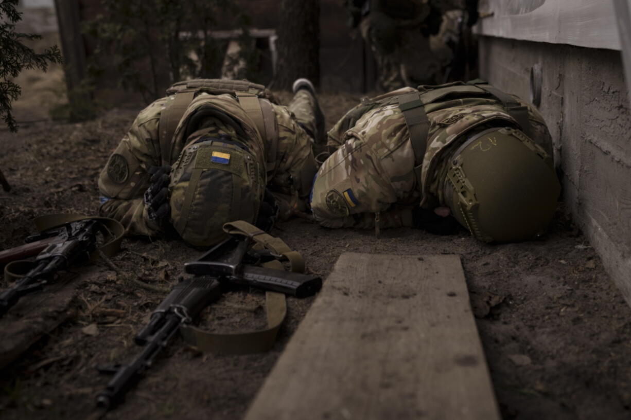 Ukrainian soldiers take cover from incoming artillery fire in Irpin, the outskirts of Kyiv, Ukraine, Sunday, March 13, 2022.