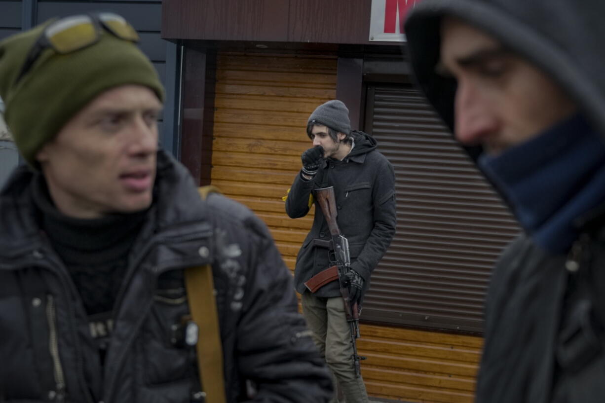 Members of the Ukrainian territorial defense guard a checkpoint in Gorenka, outside the capital Kyiv, Ukraine, Wednesday, March 2, 2022. Russia renewed its assault on Ukraine's second-largest city in a pounding that lit up the skyline with balls of fire over populated areas, even as both sides said they were ready to resume talks aimed at stopping the new devastating war in Europe.