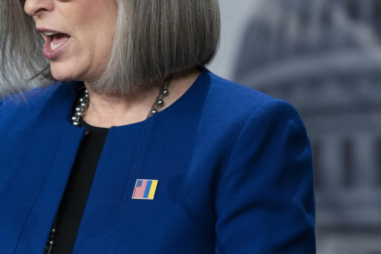 Sen. Joni Ernst, R-Iowa, wears a pin in support of Ukraine as she speaks with reporters about aid to Ukraine, on Capitol Hill, Wednesday, March 10, 2022, in Washington.