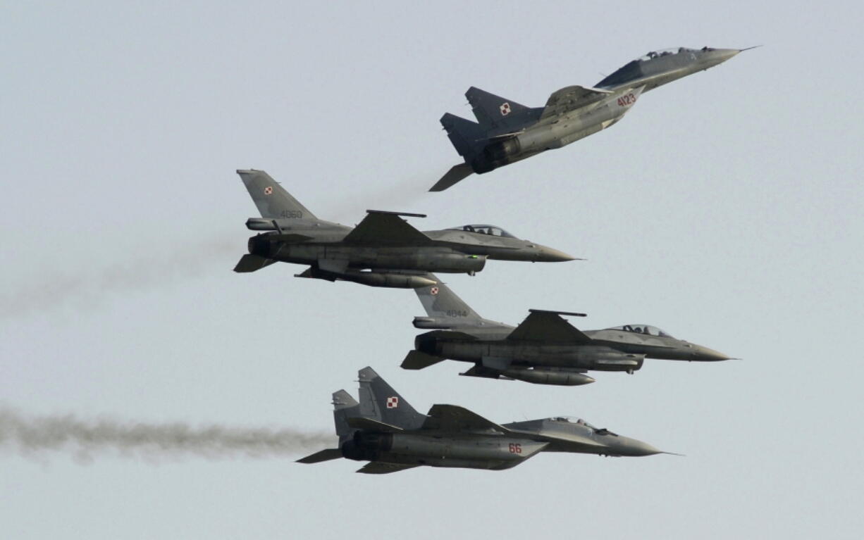 Two Polish Air Force Russian made Mig 29s fly above and below two Polish Air Force U.S.-made F-16s fighter jets during the Air Show in Radom, Poland, in 2011.