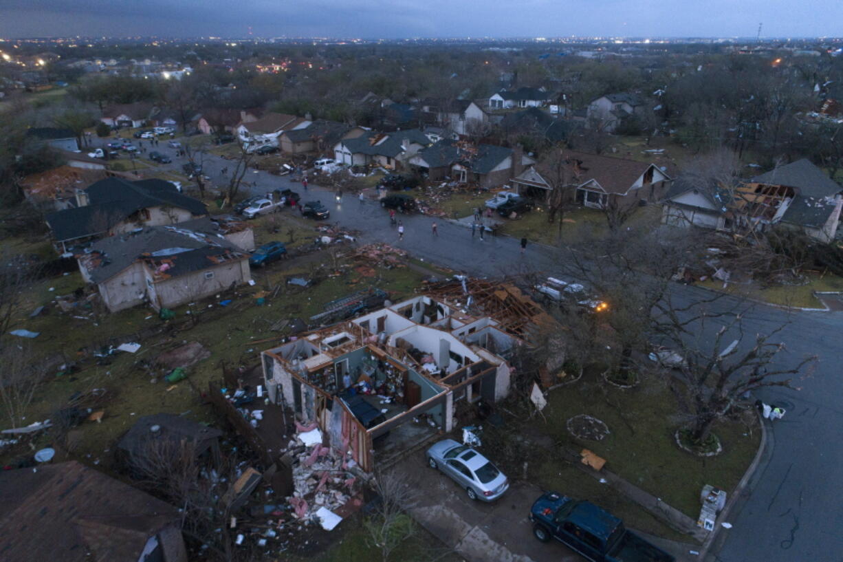 Debris litters the ground surrounding homes, damaged by a tornado, on Oxford Drive and Stratford Drive in Round Rock, Texas Monday, March 21, 2022.