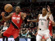 Portland Trail Blazers guard Kris Dunn, left, and San Antonio Spurs guard Dejounte Murray go after a rebound during the first half of an NBA basketball game in Portland, Ore., Wednesday, March 23, 2022.