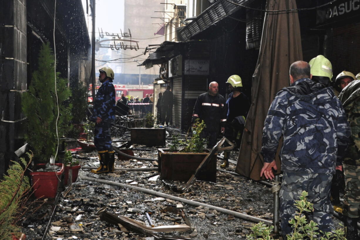 This photo released by the Syrian official news agency SANA, shows firefighters working at the scene of a fire that broke out in the La Mirada Mall building, in Damascus, Syria, Tuesday, March. 1, 2022. SANA said 11 people died and seven others were injured.