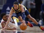 Indiana Pacers guard Tyrese Haliburton, right, and Portland Trail Blazers guard Brandon Williams, left, go for the ball during the first half of an NBA basketball game in Indianapolis, Sunday, March 20, 2022.