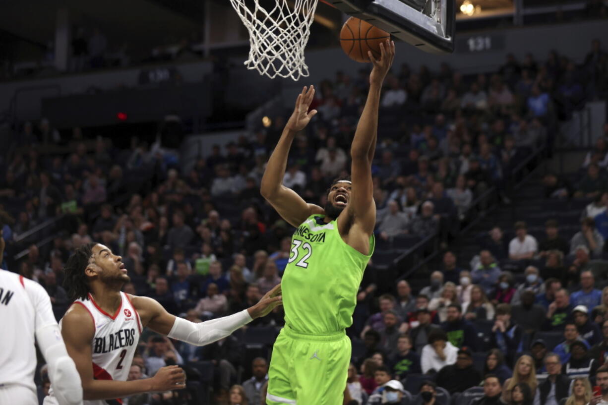 Minnesota Timberwolves center Karl-Anthony Towns (32) shoots next to Portland Trail Blazers forward Trendon Watford (2) during the first half of an NBA basketball game Saturday, March 5, 2022, in Minneapolis.