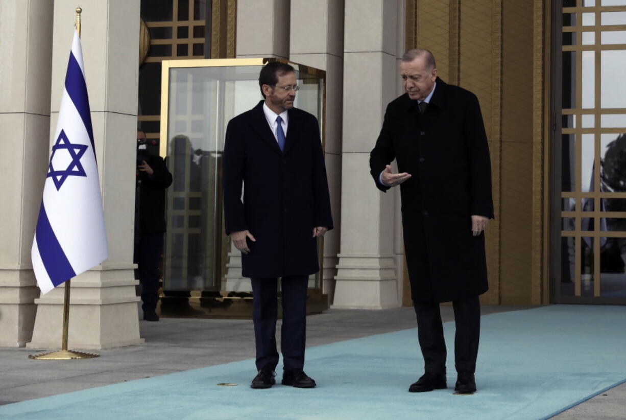 Turkish President Recep Tayyip Erdogan, right, shows the way to Israel's President Isaac Herzog pose during a welcome ceremony, in Ankara, Turkey, Wednesday, March 9, 2022. President Isaac Herzog is the first Israeli leader to visit Turkey since 2008.