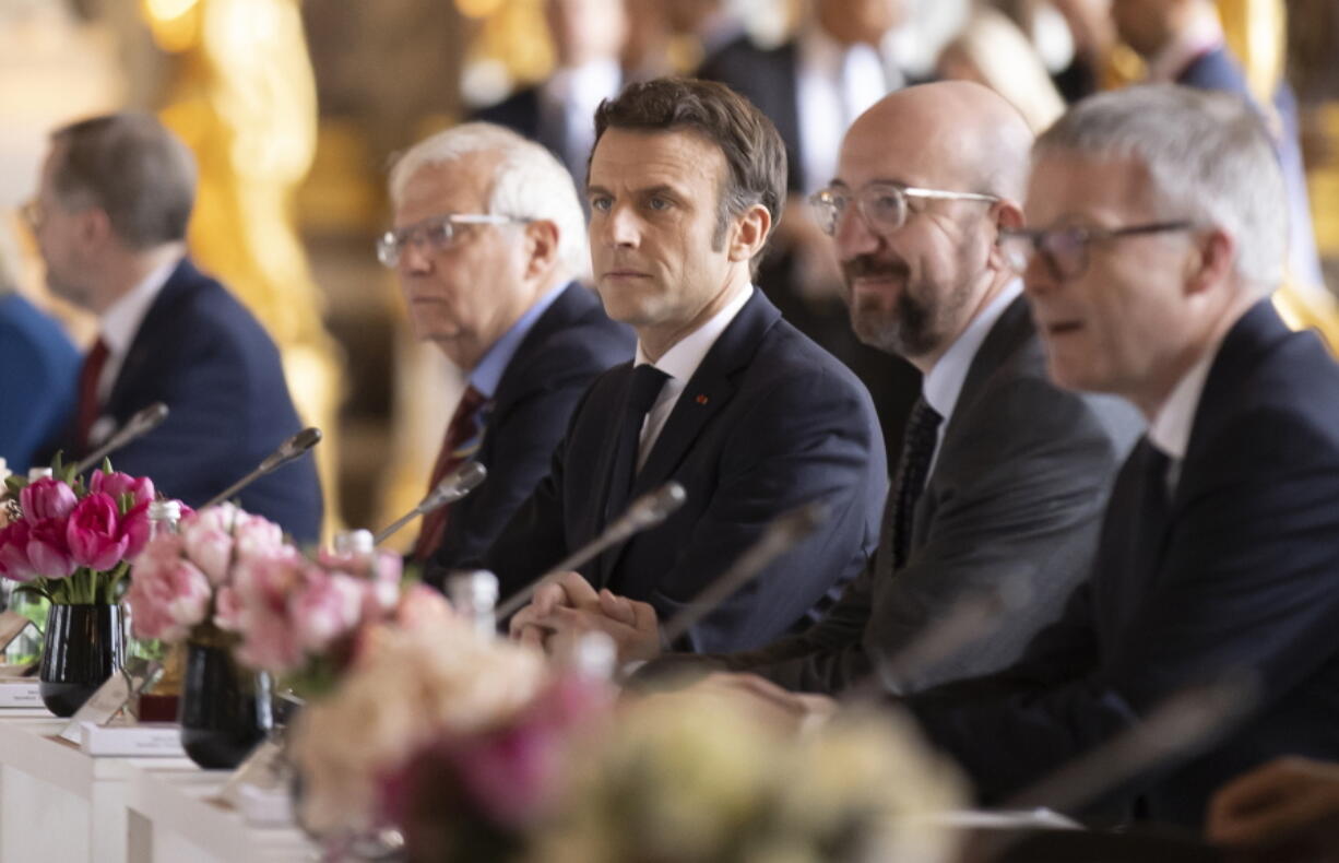 French President Emmanuel Macron, center, flanked by President of the European Council Charles Michel, second right, and High Representative of the European Union for Foreign Affairs and Security Policy Josep Borrell, second left, attend an informal EU summit at the Chateau de Versailles in Versailles, west of Paris, Friday March 11, 2022.