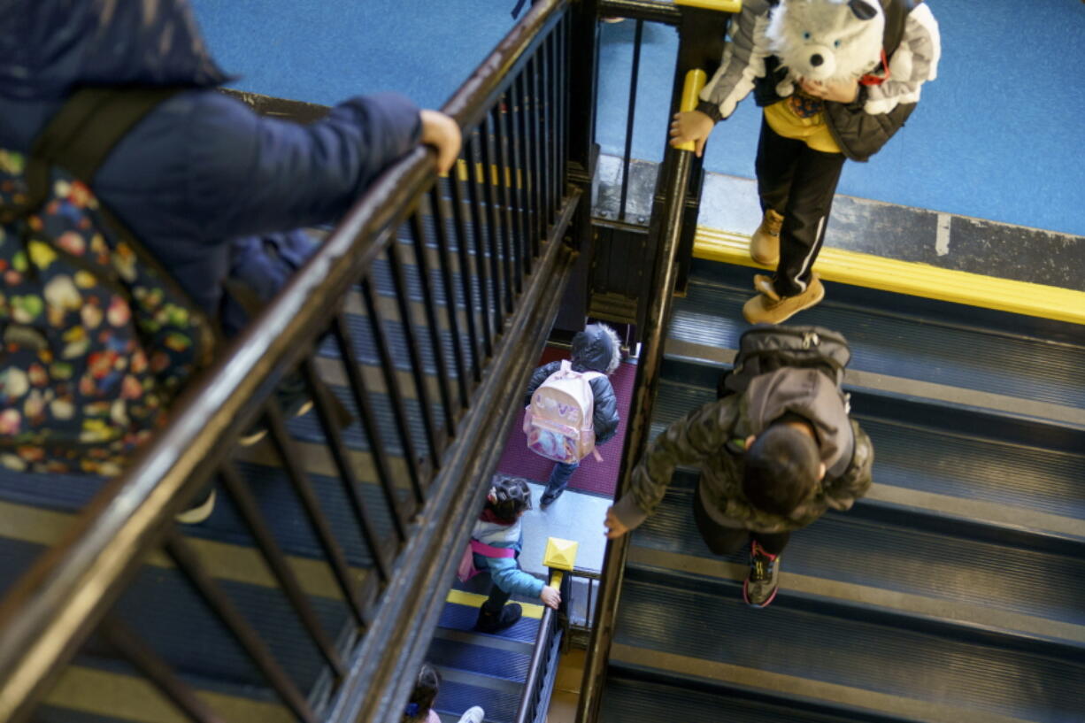 Students head down the stairs after dismissal Feb. 9 at Raices Dual Language Academy, a public school in Central Falls, R.I. The return to classrooms has not meant a return to work for many parents, who are finding after-school programs in short supply.