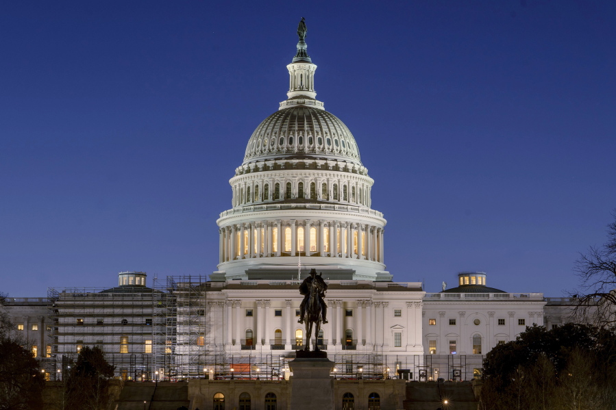 FILE - The U.S. Capitol building is seen before sunrise on Capitol Hill in Washington, Monday, March. 21, 2022. With an urgent funding request stuck in Congress, the Health Resources and Services Administration says it can no longer cover medical bills for COVID tests and treatments for uninsured people and will stop taking claims at midnight Tuesday.