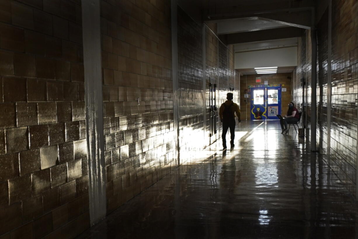 FILE - A student walks down a hallway between classes at a high school in Kansas City, Kan., on the first day of in-person learning Wednesday, March 30, 2021. According to a study by the Centers for Disease Control and Prevention released on Thursday, March 31, 2022, nearly half of U.S. high school students said they felt persistently sad or hopeless during the COVID-19 pandemic, and many said they suffered emotional or physical abuse by a parent or other adult in the home.