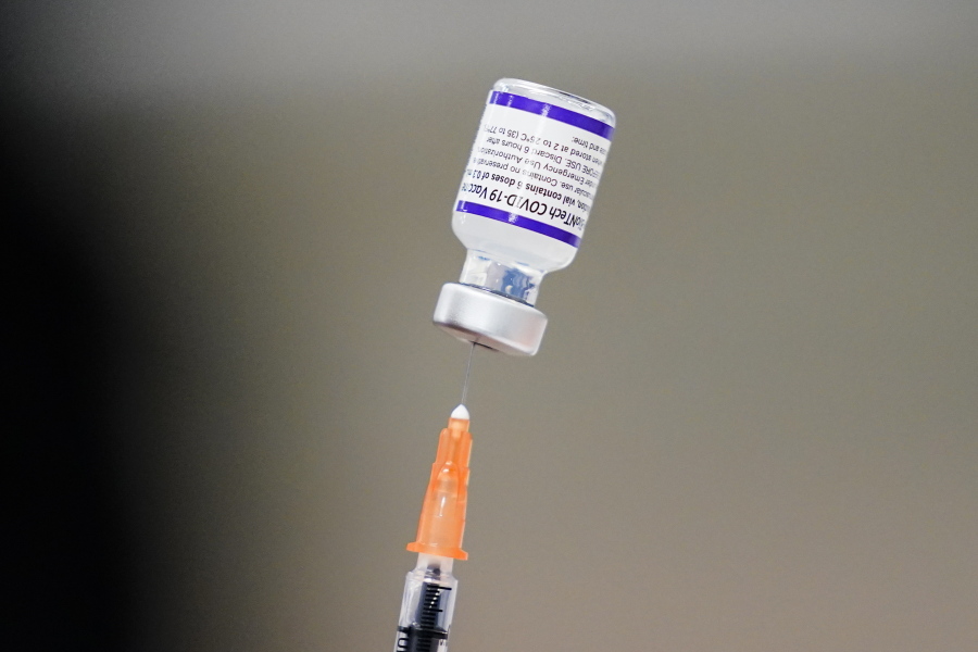 FILE - A syringe is prepared with the Pfizer COVID-19 vaccine at a vaccination clinic at the Keystone First Wellness Center in Chester, Pa., on Dec. 15, 2021. Pfizer is expected to request authorization for an additional COVID-19 booster dose for seniors.