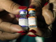 A nurse holds a vial of the Pfizer COVID-19 vaccine for children ages 5 - 11, right, and a vial of the vaccine for adults, which have different colored labels, at a vaccination station in Jackson, Miss., Tuesday, Feb. 8, 2022. Pfizer's COVID-19 vaccine gave children 5 and older strong protection against hospitalization and death even during the omicron surge that hit youngsters especially hard, according to new data from the Centers for Disease Control and Prevention released on Tuesday, March 1, 2022. (AP Photo/Rogelio V.