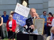 FILE- Jefferson E. Davis, spokesman for a group pushing for a broad review of the 2020 presidential election in Wisconsin, holds up a copy of the Declaration of Independence before leading a group of about 100 people into the state Capitol offices of Republican state leaders asking them to sign subpoenas for access to voting machines, ballots and other election material, on Sept. 10, 2021, in Madison, Wis. The push by Republicans to conduct partisan ballot reviews like the one that unfolded last year in Arizona has spread beyond battleground states disputed by former President Donald Trump. Lawmakers in GOP-dominated state legislative chambers are calling not only for another look at the 2020 presidential election but also the ability to question future contests.