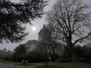 The sun appears through cloudy skies Thursday, March 10, 2022, above the Legislative Building at the Capitol in Olympia, Wash. Washington lawmakers were wrapping up their work Thursday with final votes on a supplemental state budget and a transportation revenue package before planning to adjourn the legislative session. (AP Photo/Ted S.